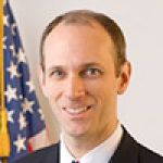 A professional headshot of a man.